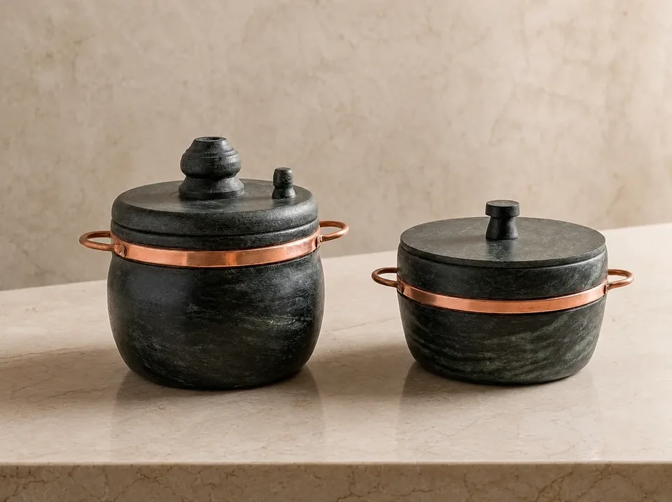 Kit 2 Panelas de pedra sabão com alças de cobre sobre bancada de mármore