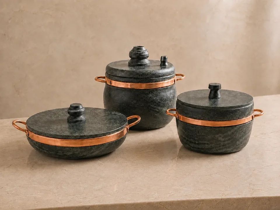 Kit 3 Panelas de pedra sabão com alças de cobre sobre bancada de mármore