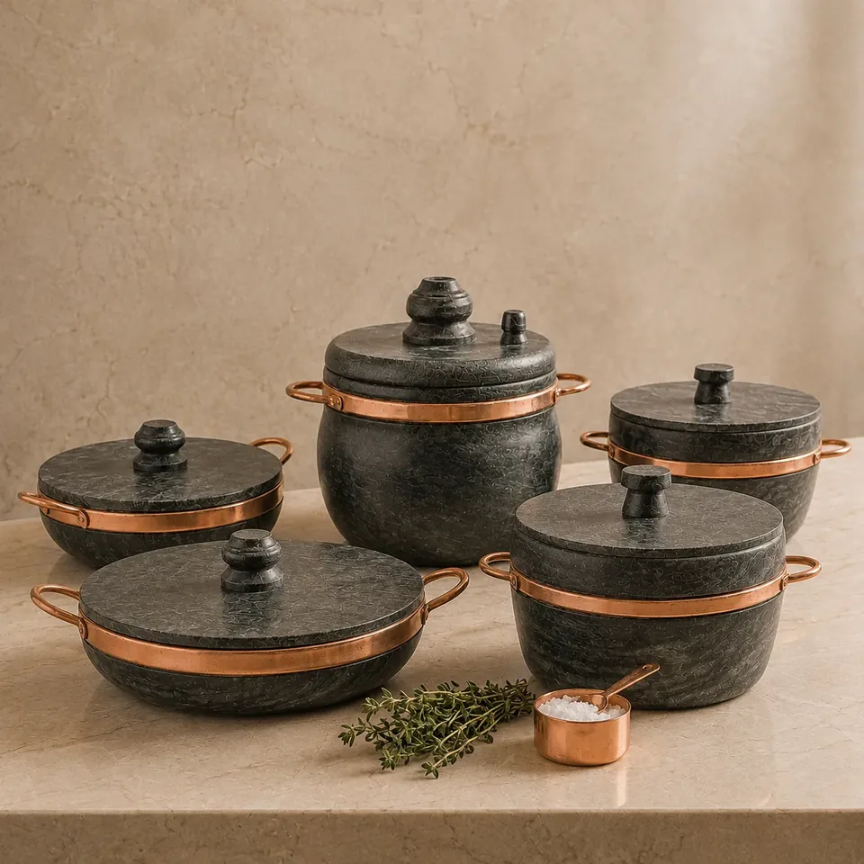 Kit 5 Panelas de pedra sabão com alças de cobre sobre bancada de mármore
